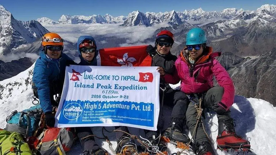 Climbers holding a Hong Kong flag and a High 5 Island Peak Expedition banner, on the summit of Island Peak, October 2016