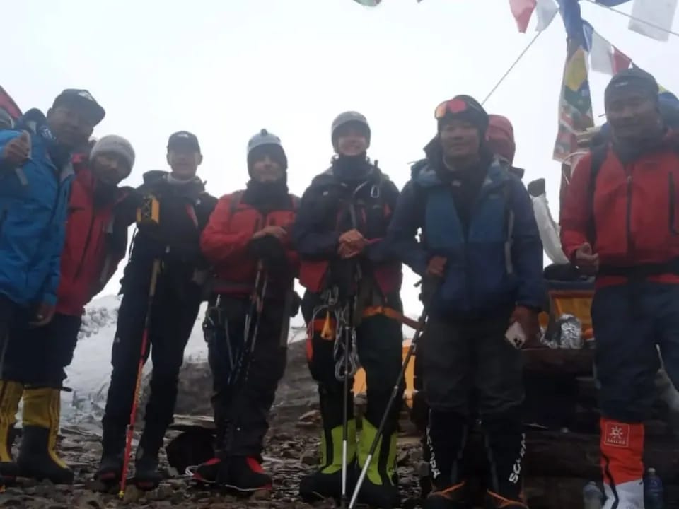 What our expedition team provides: The climbing team at Manaslu Base Camp. Seven climbers in high-altitude boots and harnesses under prayer flags, Manaslu Base Camp. Seven climbers in high-altitude boots and harnesses under prayer flags, Manaslu Base Camp